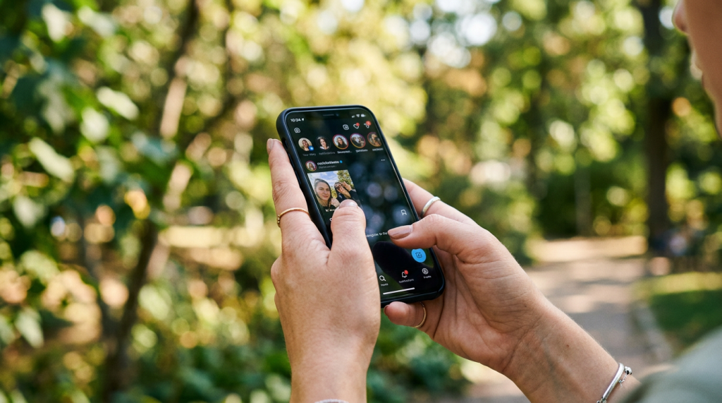 Hands holding smartphone displaying Instagram app interface